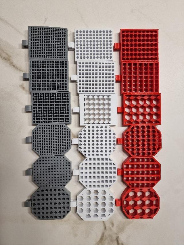 Eighteen 3D-printed grid fins arranged by outer outline, hole shape, and hole size