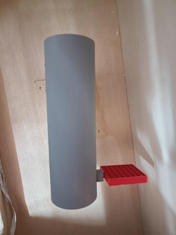 Model rocket with a red grid fin installed inside the wind-tunnel test section